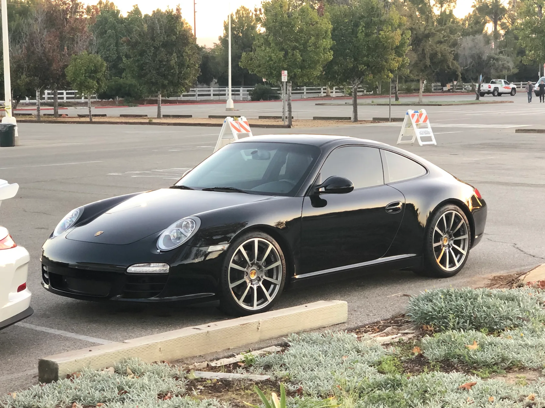 The Stable’s black Porsche 997 Carrera parked, seen from the front and side